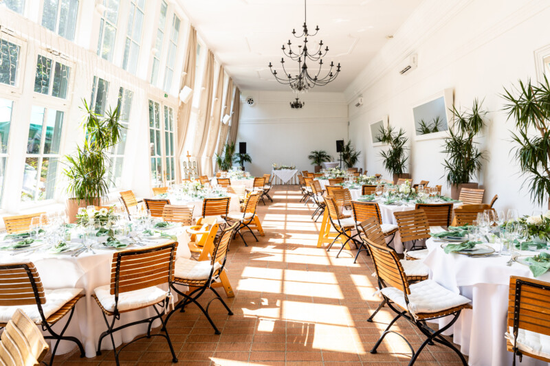 Gedeckte Hochzeitstische in der Orangerie mit Sicht auf den ganzen Raum – Hochzeits- und Eventlocation Europahaus Wien